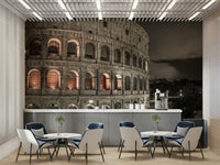 The image shows a full wall with the Colosseum lit up after dark.

