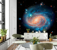 Cosmic Symphony wallpaper mural of a spiral galaxy above a white console with plants in a loft living room