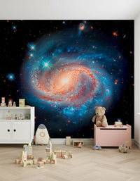 Cosmic Symphony wallpaper mural of a spiral galaxy in a kids playroom with a teddy bear and wooden building blocks