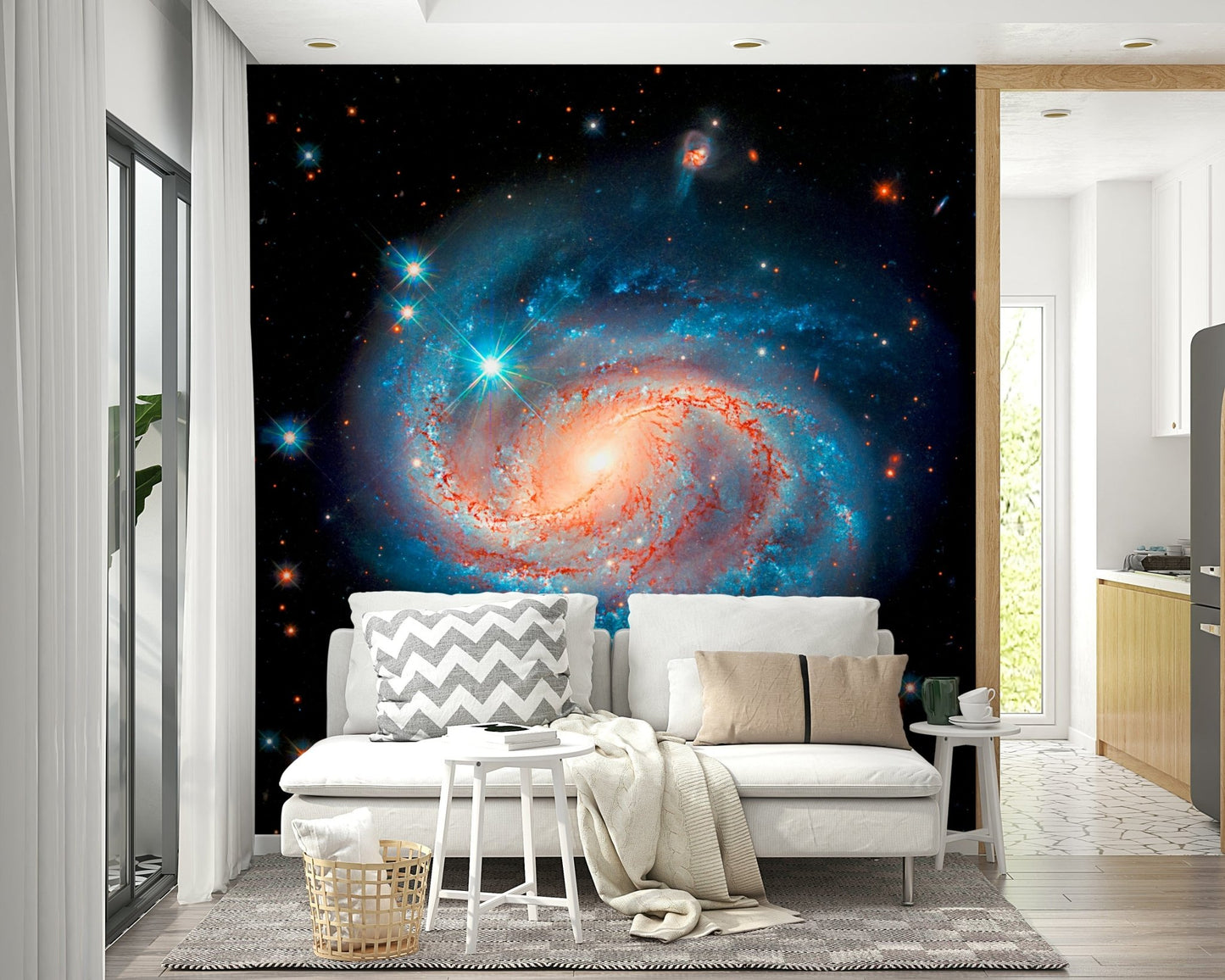 Cosmic Symphony wallpaper mural with a spiral galaxy behind a white sofa beside an open-plan kitchen
