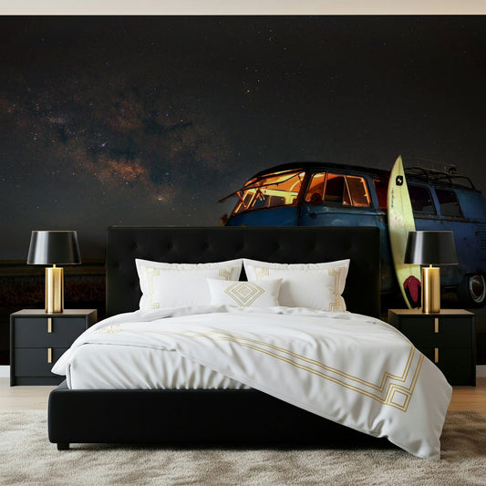 Cosmic Rides wallpaper mural of a starry-sky campervan scene in a bedroom with black tufted bed and gold lamps