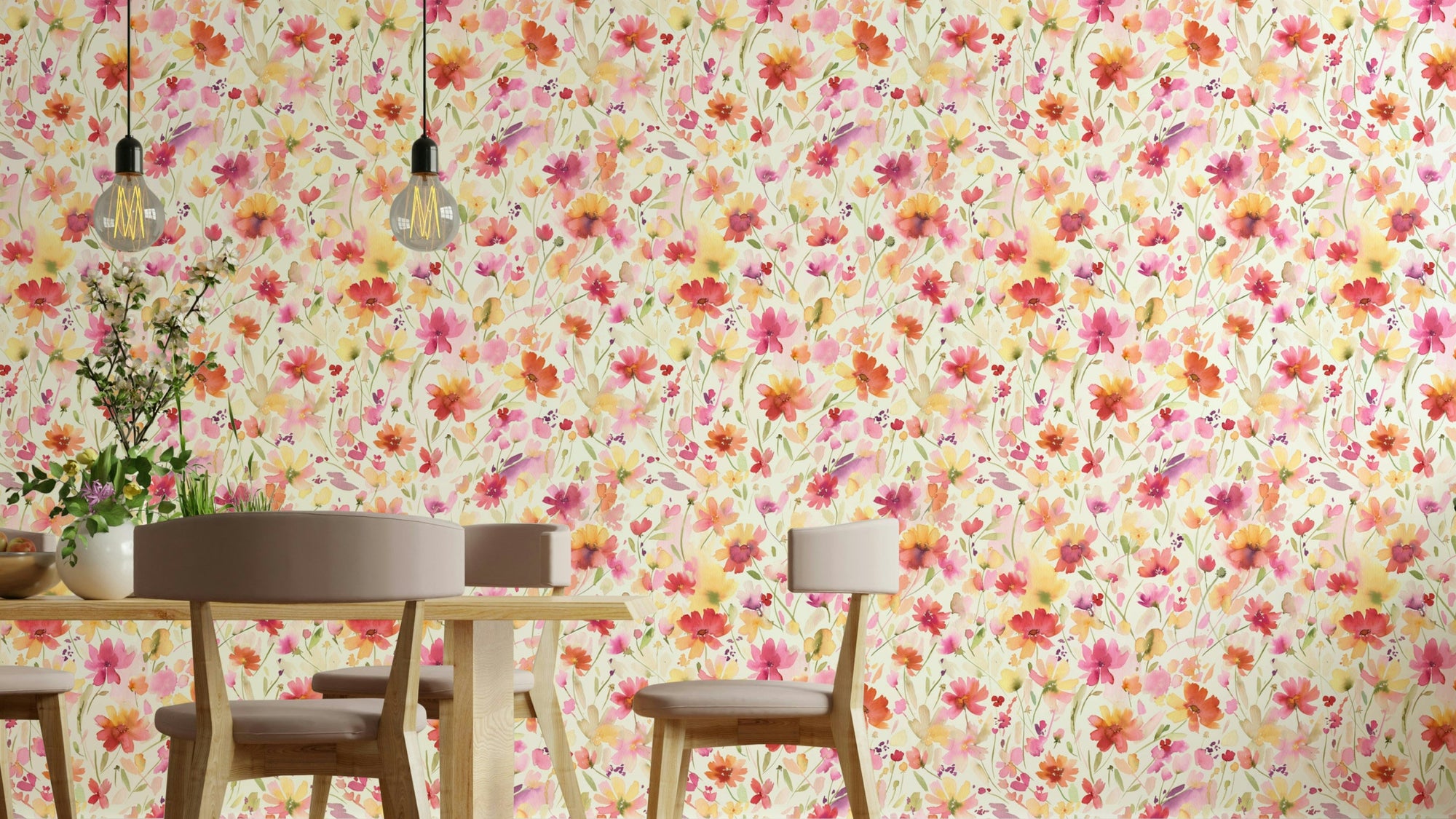 Cosmos wildflowers wallpaper in pink and orange behind a round dining table with wood chairs and Edison pendant lights