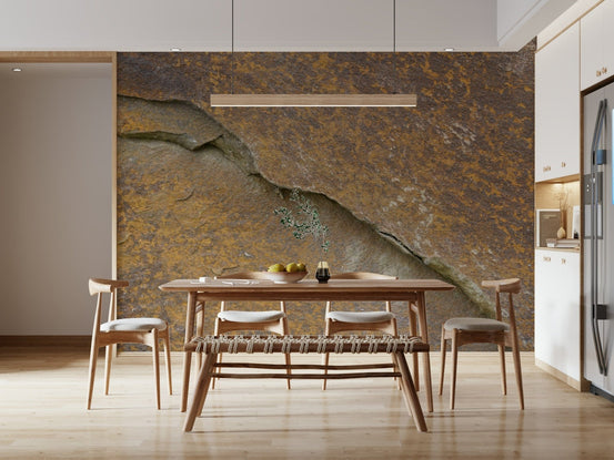 Cracked stone wallpaper mural in rusty orange behind a wooden dining table and bench in a dining room