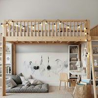 Crane Dance in White wallpaper mural of ink-wash cranes behind a wood loft bed and grey floor cushion in a kids room