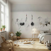 Crane Dance in White wallpaper mural of grey cranes behind a white bed and two rattan chairs in a kids room