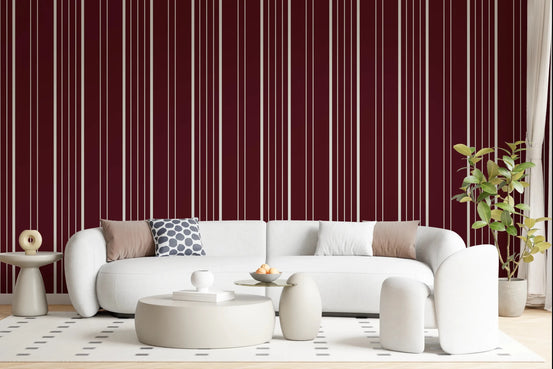 Crimson Stripes wallpaper in a living room with a white curved sofa, round tables and rubber plant
