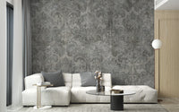 Damask wallpaper styled as a feature wall behind a dining table and chairs in gray tones