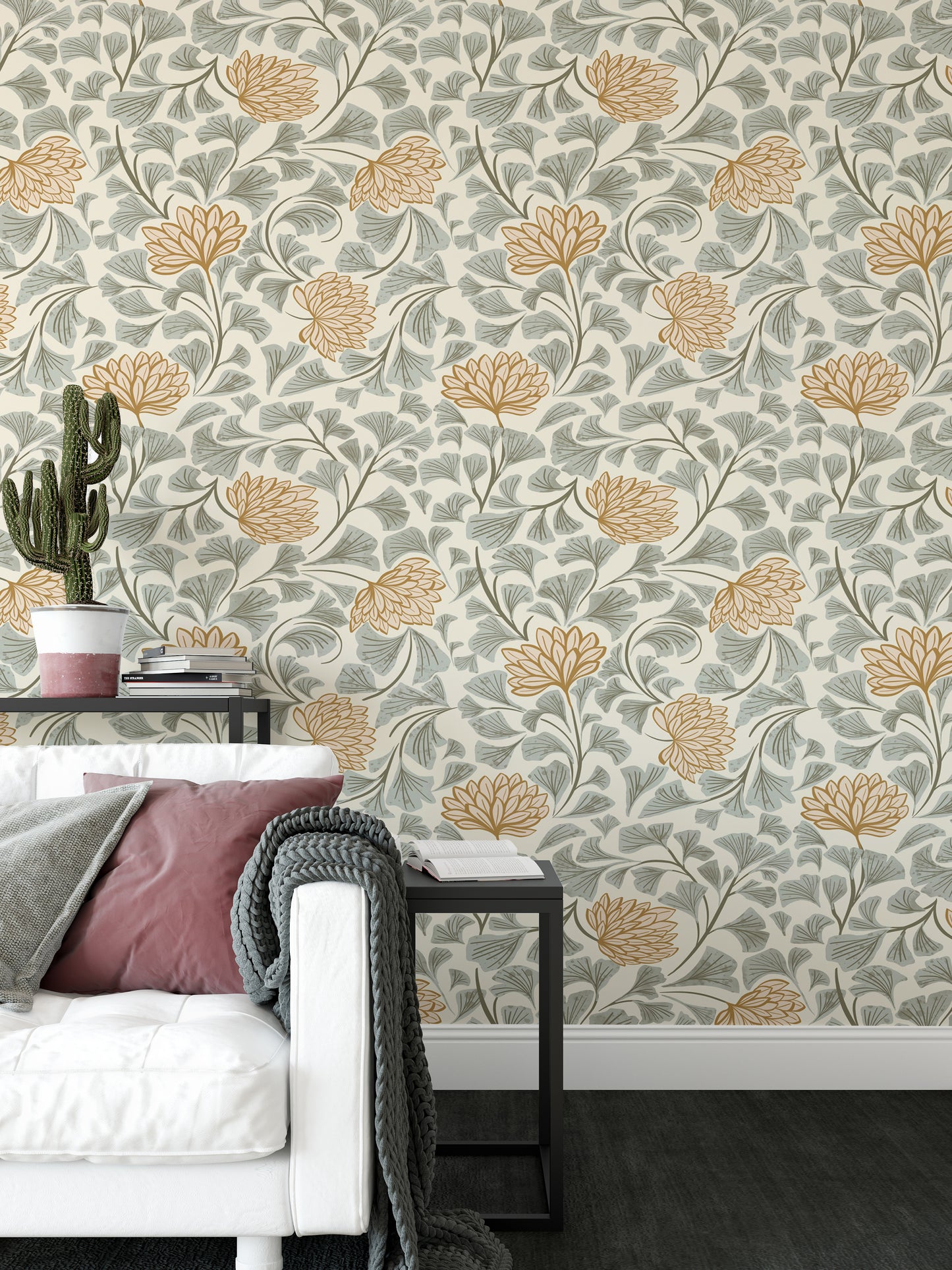 Dancing Bloom wallpaper with orange flowers and grey ginkgo leaves behind a white sofa with pink cushions in a living room