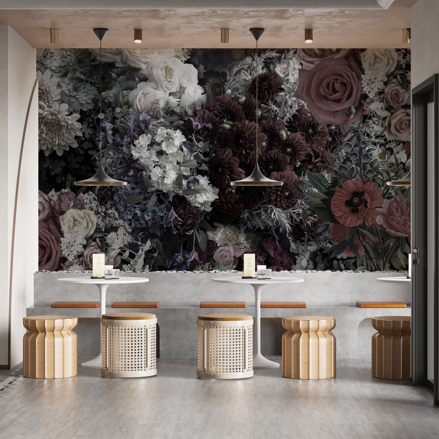 Dark Floral wallpaper mural behind pedestal tables and rattan stools in a moody dining seating area