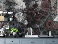 Dark Floral wallpaper mural above blue-grey cabinets and a white sink in a moody kitchen with dark blooms