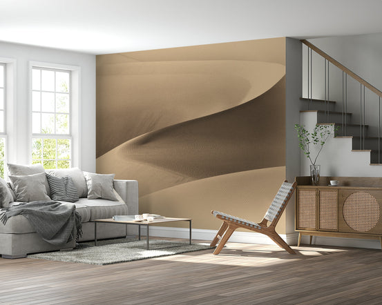 Desertscape wallpaper mural of a tan sand dune behind a grey sofa with a cane sideboard and staircase