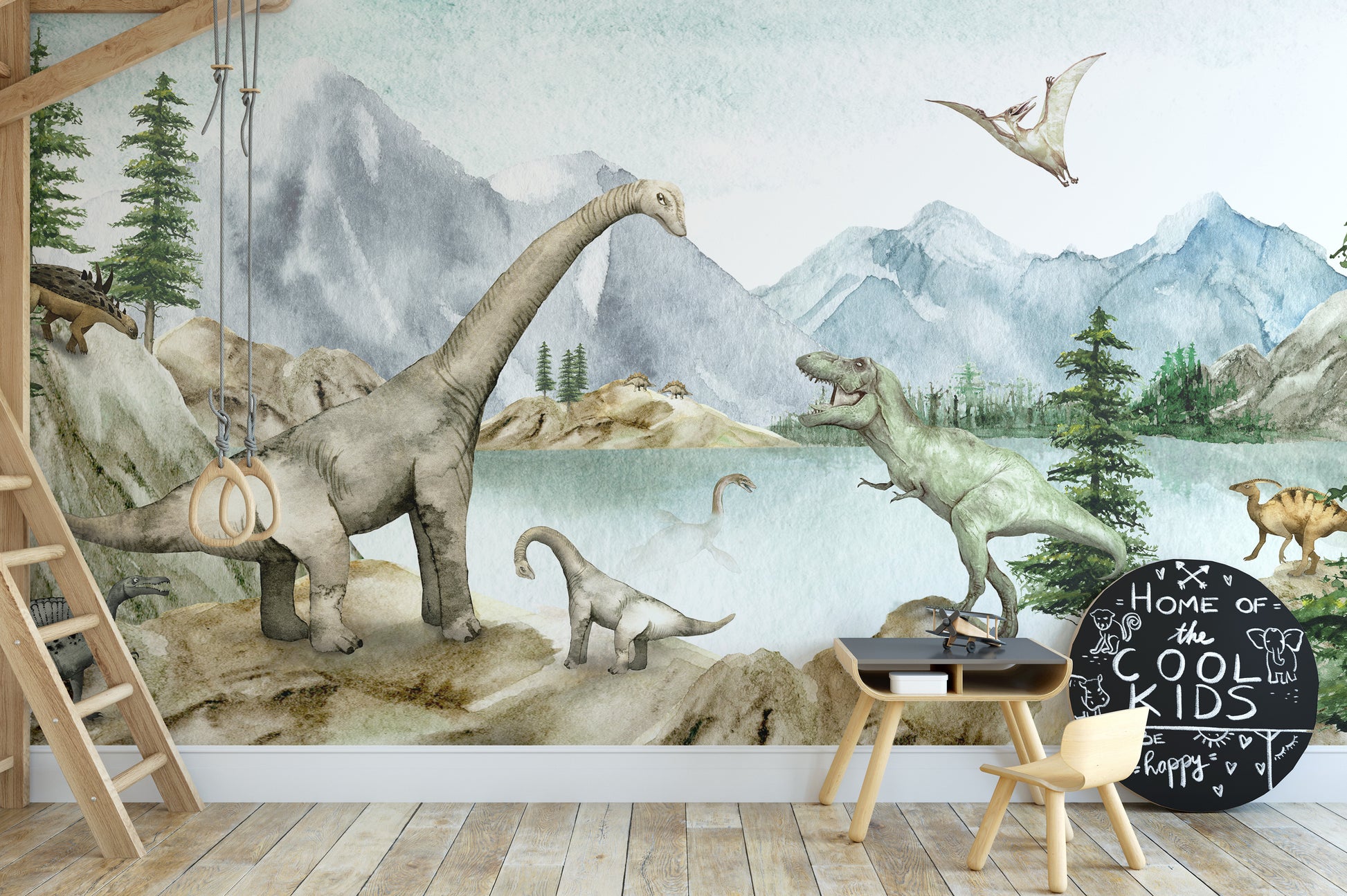 Dino dreams wallpaper mural of dinosaurs and mountains behind a loft bed ladder and Cool Kids chalkboard in a kids room