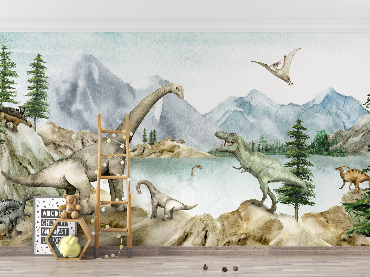 Dino dreams wallpaper mural of green watercolor dinosaurs by a lake above a kids room with a ladder and teddy bear