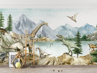 Dino dreams wallpaper mural of green watercolor dinosaurs by a lake above a kids room with a ladder and teddy bear