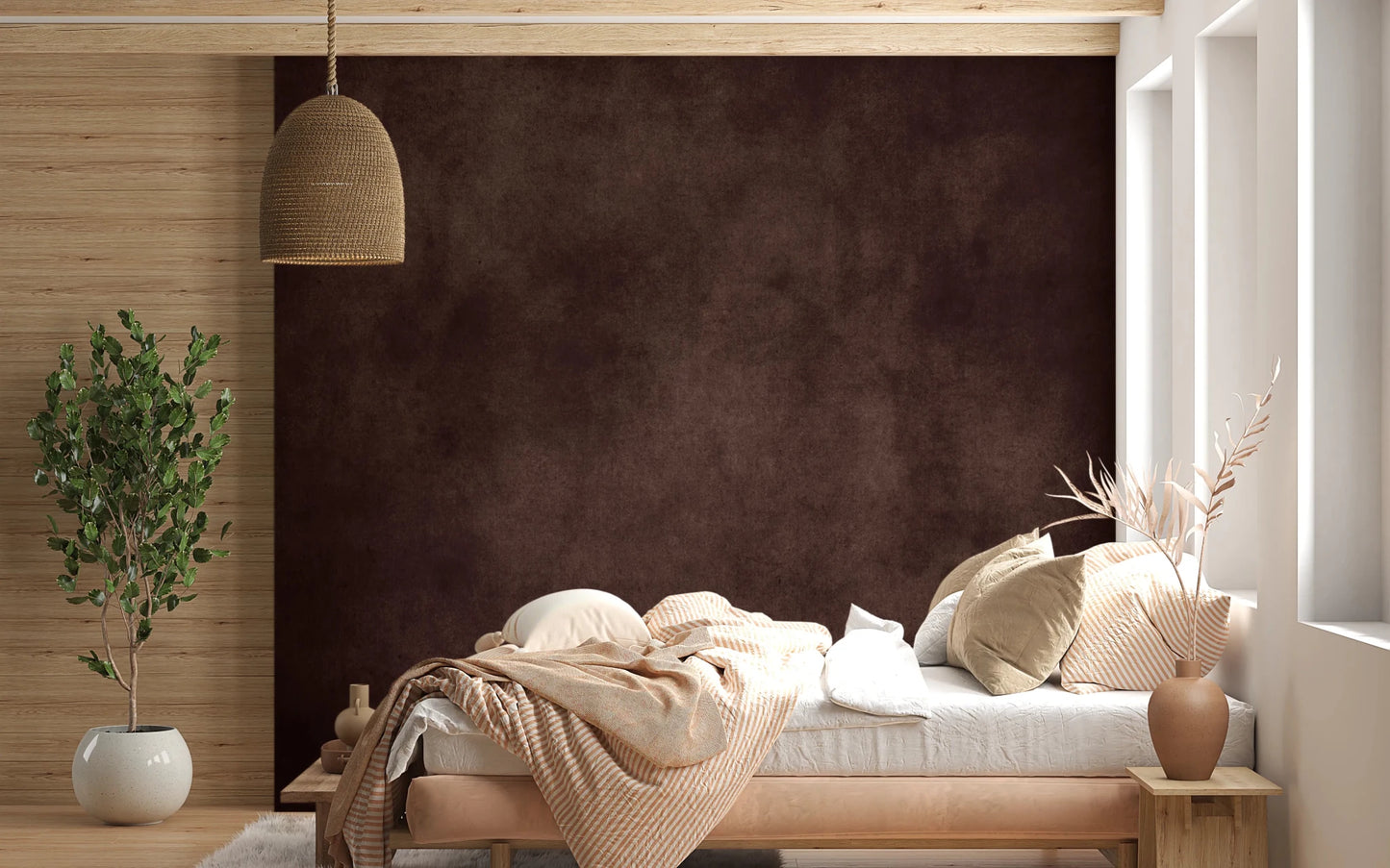 Dirty Paper Cognac wall mural in deep brown behind a low wood bed with peach striped bedding and rattan pendant