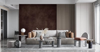 Dirty Paper Cognac wall mural in cognac brown framed by wood slats behind a grey sofa and pampas grass