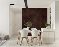 Dirty Paper Cognac wall mural in rich brown behind a white dining table and chairs beside a marble counter