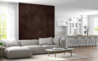 Dirty Paper Cognac wall mural in rich brown beside a white kitchen with bar stools and a grey sectional sofa