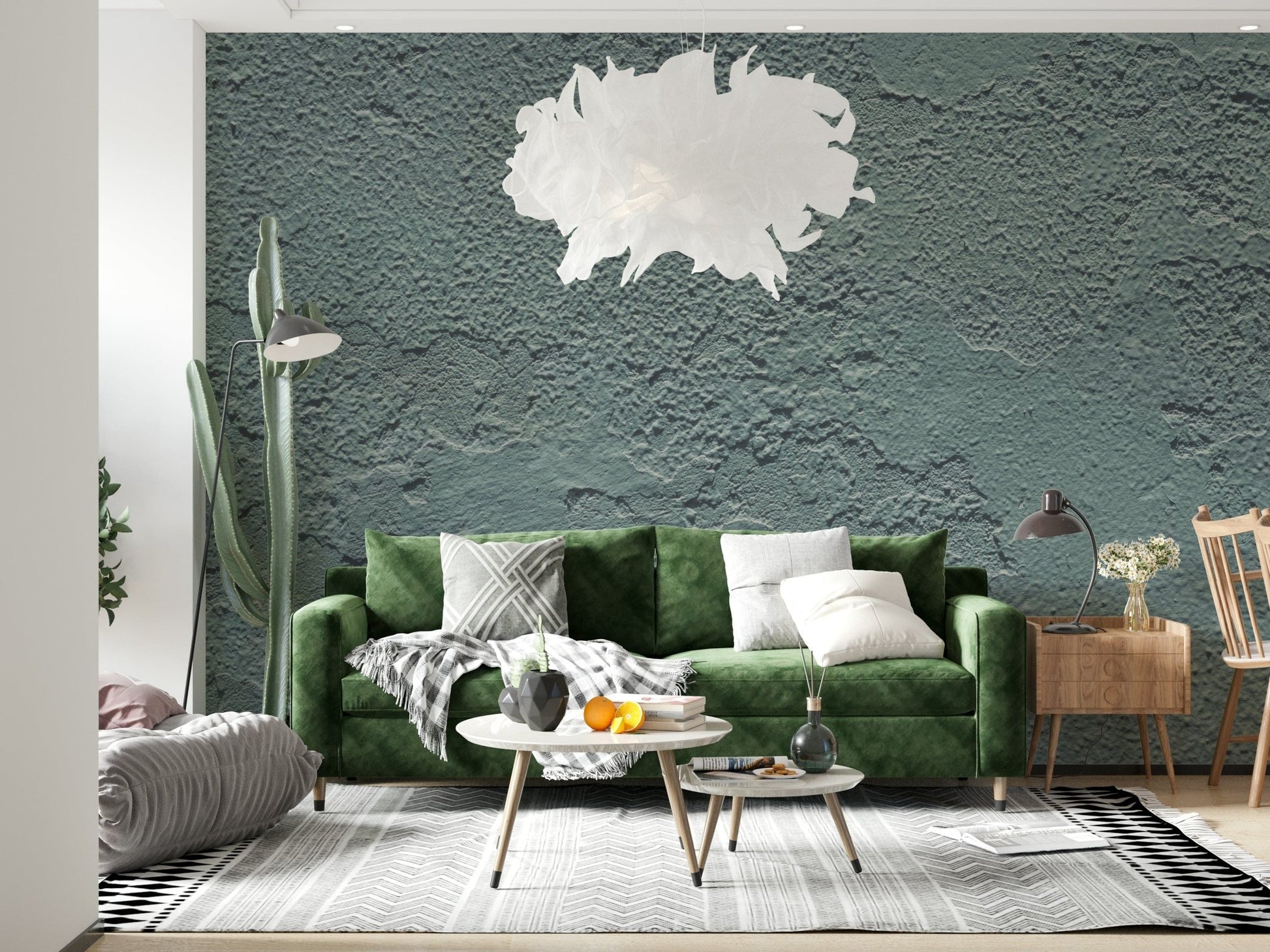 Distressed Walls wallpaper mural in grey-green textured plaster behind a green velvet sofa in a modern living room