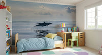 Coastal dolphin wallpaper mural behind sofa in apartment, calm sea colors, modern style