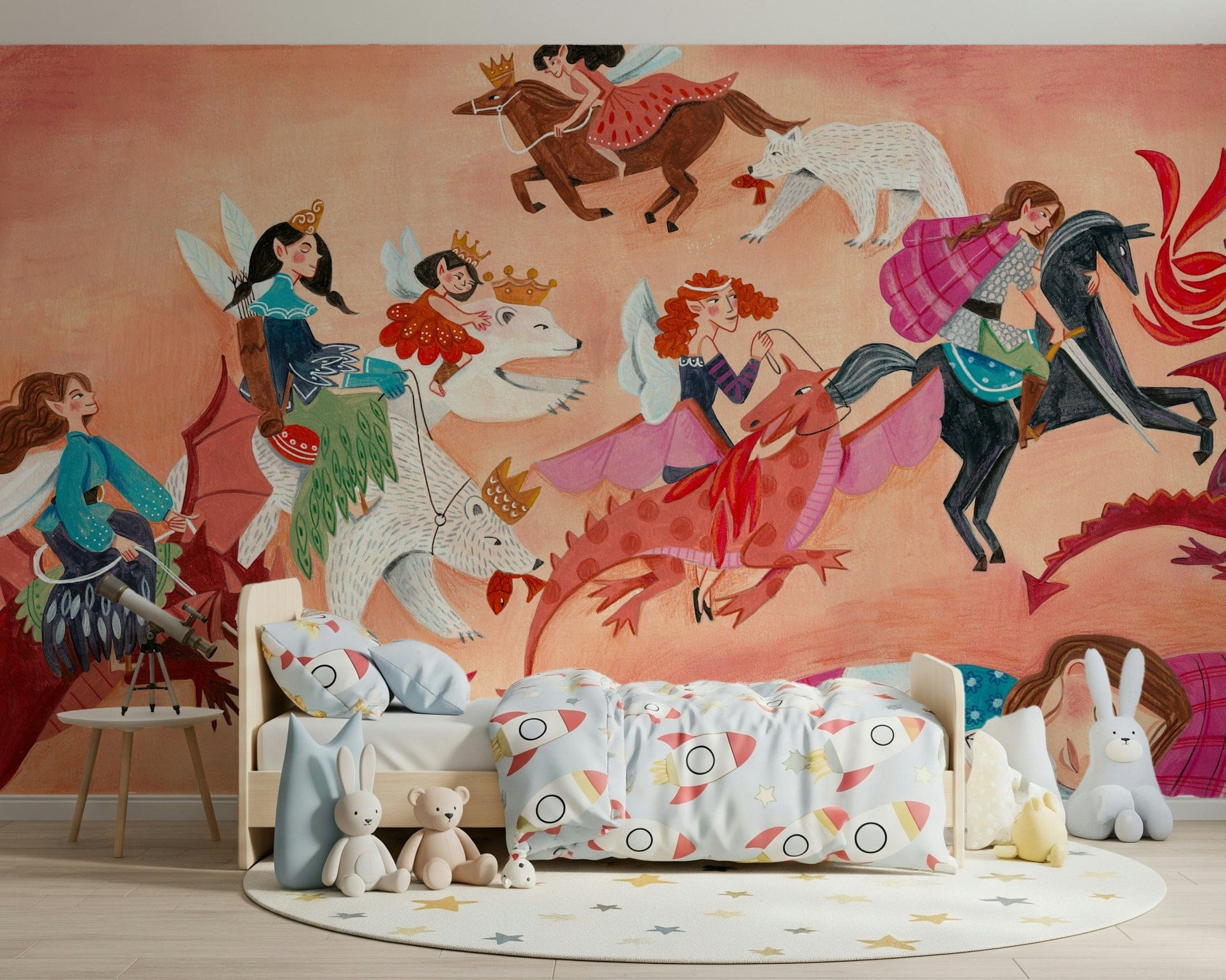 Dream Riders wallpaper mural of fairy princesses on a horse, wolf and dragons above a kids bed with rocket bedding and teddy bears