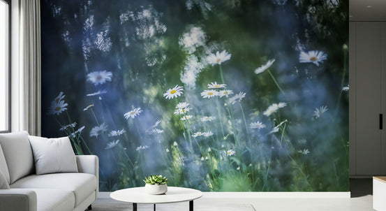 Daisy Dreamscape wallpaper mural of white daisies on a dark blue-green field beside a white sofa in a living room