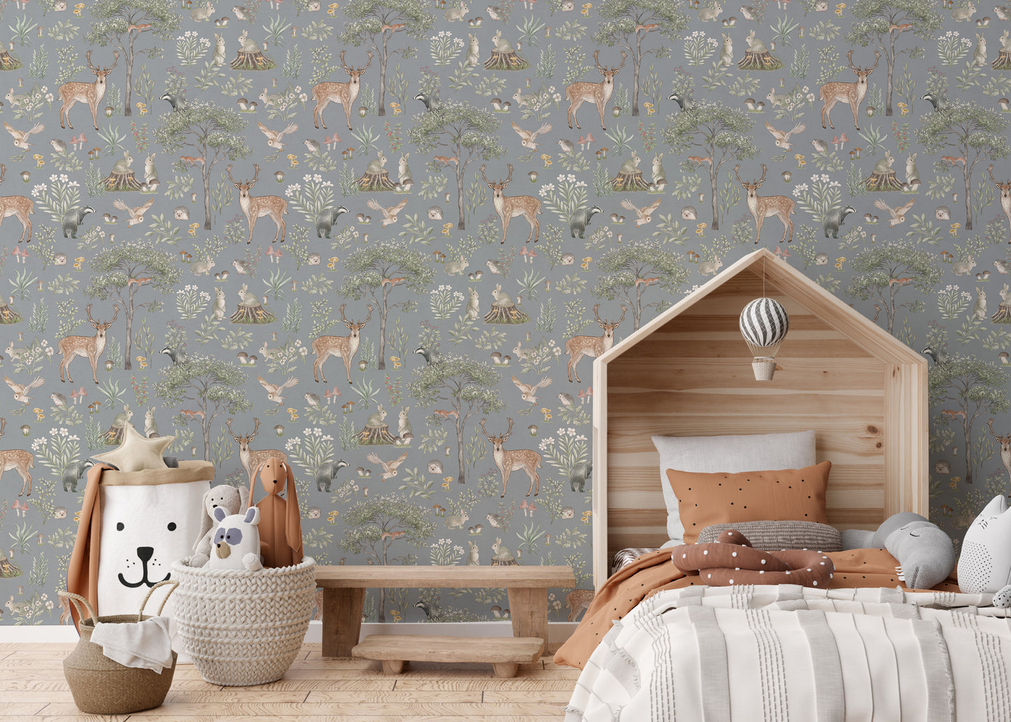 Dusty Blue Wildlife wallpaper above a wooden house bed with terracotta bedding and a balloon mobile