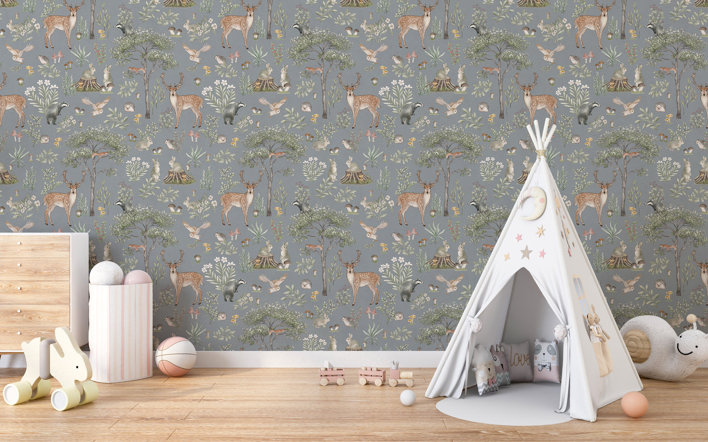 Dusty Blue Wildlife wallpaper behind a white teepee tent, drawer chest and pink storage drum