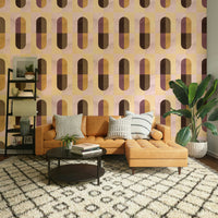 Earthy Geometric wallpaper in a living room with a tan leather sectional and bird-of-paradise plant