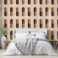 Earthy Geometric wallpaper behind a white upholstered bed with a grey throw and an olive branch vase