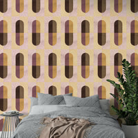 Earthy Geometric wallpaper with retro arches behind a grey quilted bed beside a tall ZZ plant