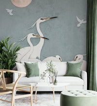 The image features several elegant egrets standing in or near calm water.
