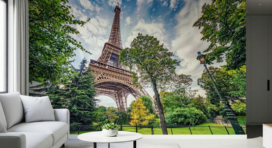 Eiffel Tower Greens wallpaper mural of the Eiffel Tower among green park trees behind a white sofa in a living room