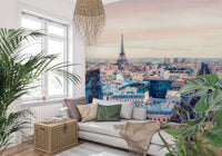 Eiffel Tower View wallpaper mural showing the Paris rooftops and tower behind a white daybed and leafy plants in a living room