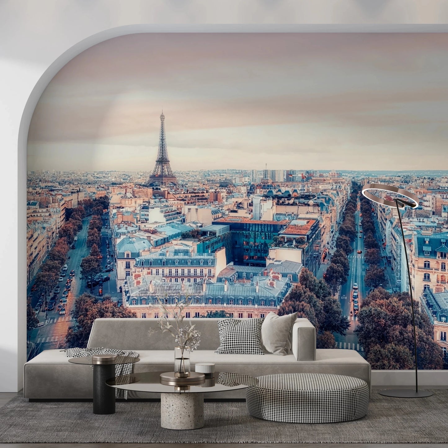 Eiffel Tower View wallpaper mural of the Paris skyline at dusk behind a grey sofa in an arched living room alcove