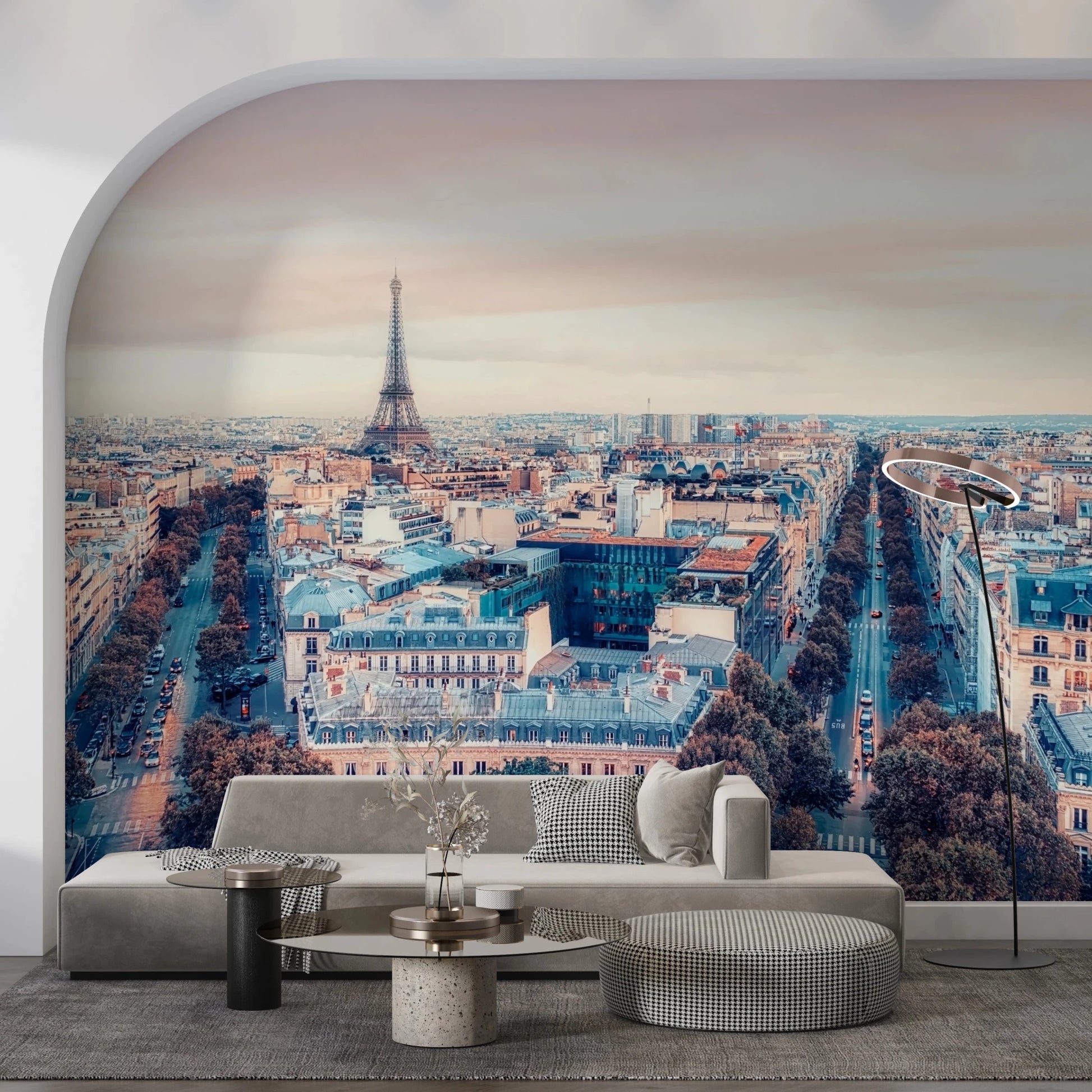 Eiffel Tower View wallpaper mural of the Paris skyline at dusk behind a grey sofa in an arched living room alcove