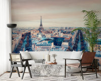 Eiffel Tower View wallpaper mural of the Paris skyline behind a white sofa and cane and leather armchairs in a living room