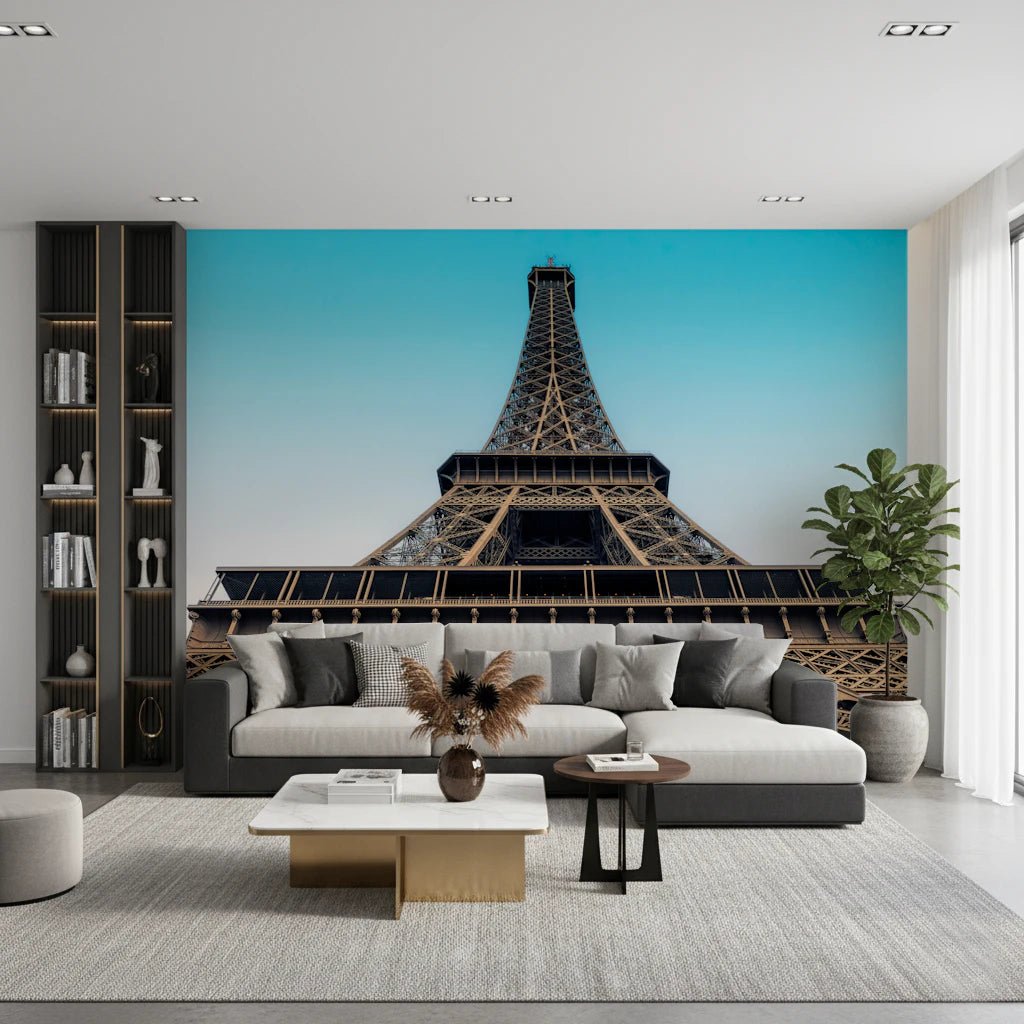 Eiffel's Azure Ascent wallpaper mural with the Eiffel Tower behind a grey sofa and dark bookshelf in a living room