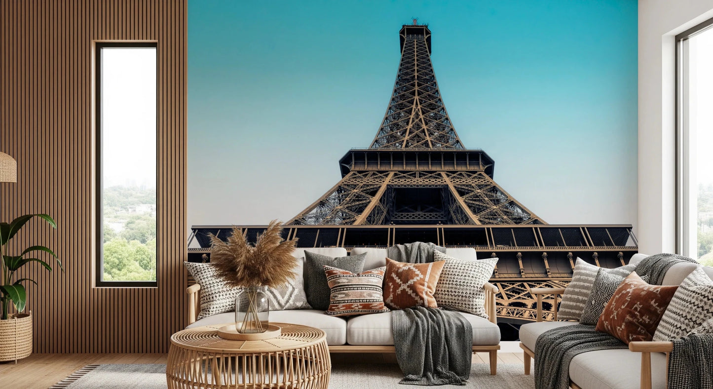 Eiffel's Azure Ascent wallpaper mural of the Eiffel Tower behind a cream sofa with boho pillows in a living room