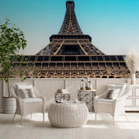 Eiffel's Azure Ascent wallpaper mural with the Eiffel Tower behind white wicker chairs in a bright sitting area