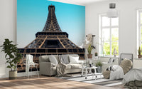 Eiffel's Azure Ascent wallpaper mural with the Eiffel Tower behind a cream sofa in a Scandinavian style living room