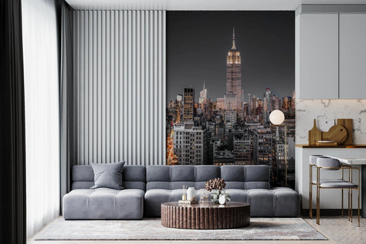 Empire State Building mural over a gray sectional sofa and round coffee table in a modern living room