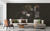 Enigmatic Cosmic wallpaper mural in charcoal with line art behind a cream sectional and terracotta chair in a living room