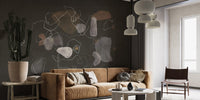 Enigmatic Cosmic wallpaper mural on a dark wall behind a tan velvet sofa and tall cactus in a living room