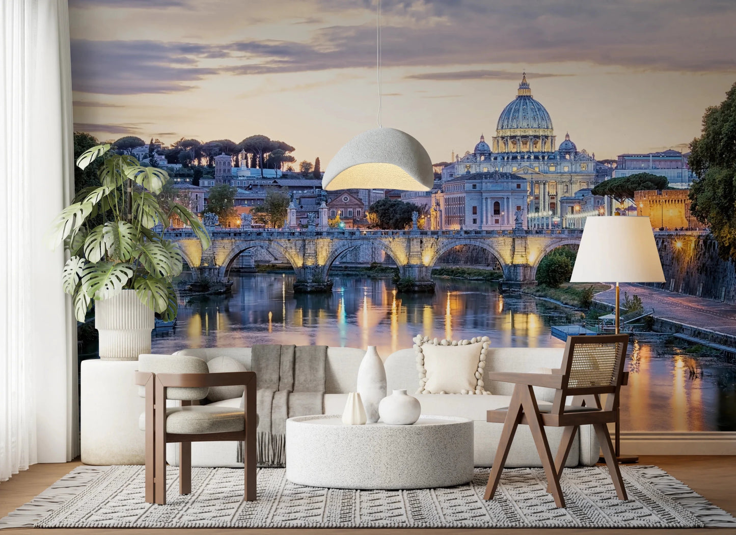 Eternal City Lights wallpaper mural of Rome's St Peter's dome and lit bridge above a cream curved sofa and monstera