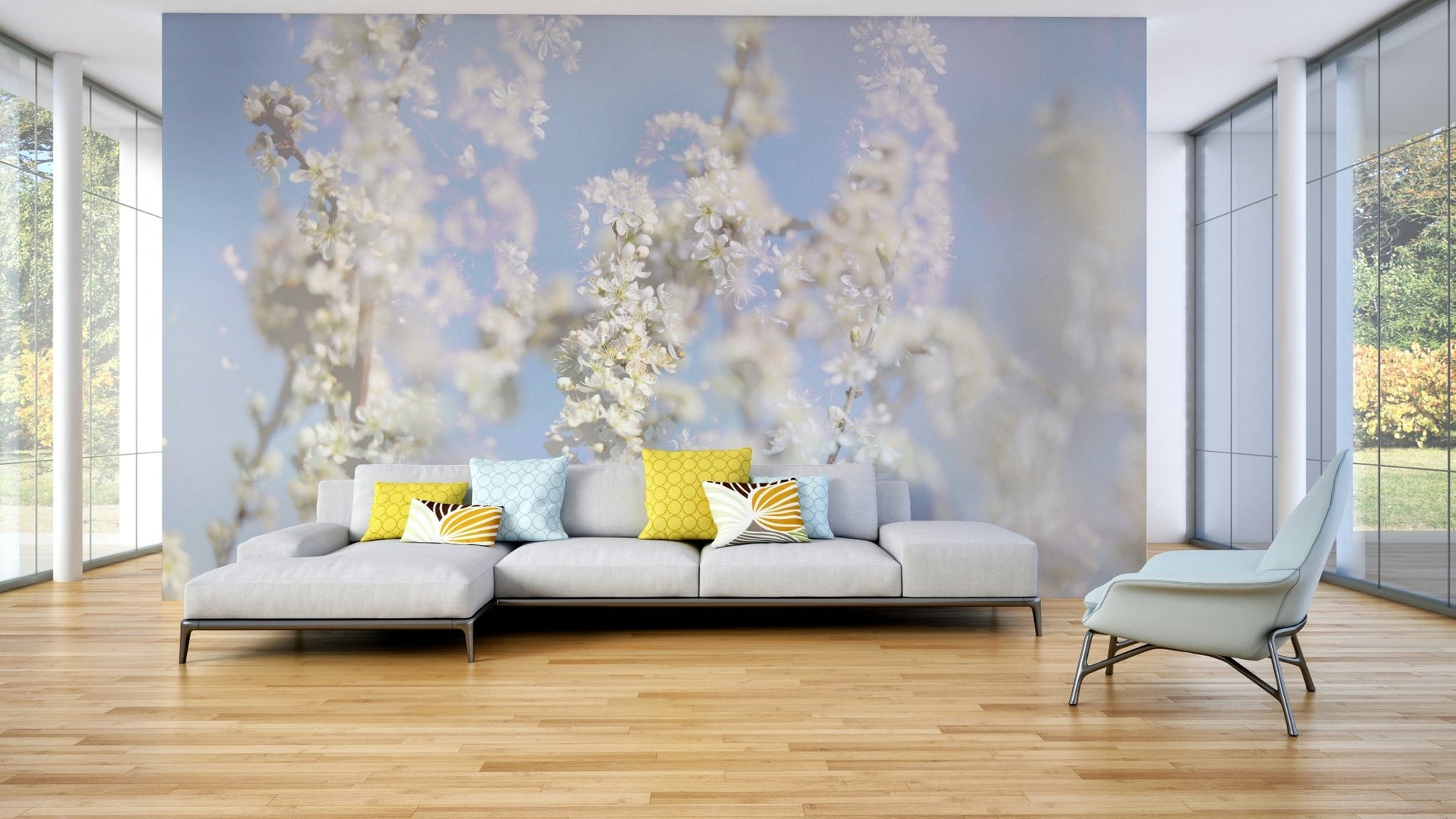 Ethereal Blossom Photography soft white floral wall mural behind a gray sofa with yellow pillows in a glass-walled living room