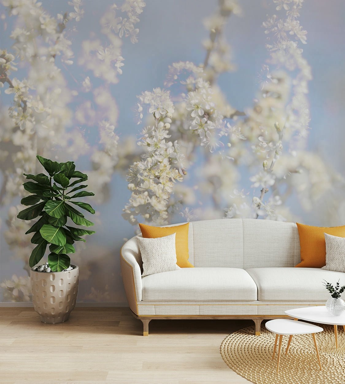 Ethereal Blossom Photography soft white floral wall mural behind a cream curved sofa with orange pillows in a living room