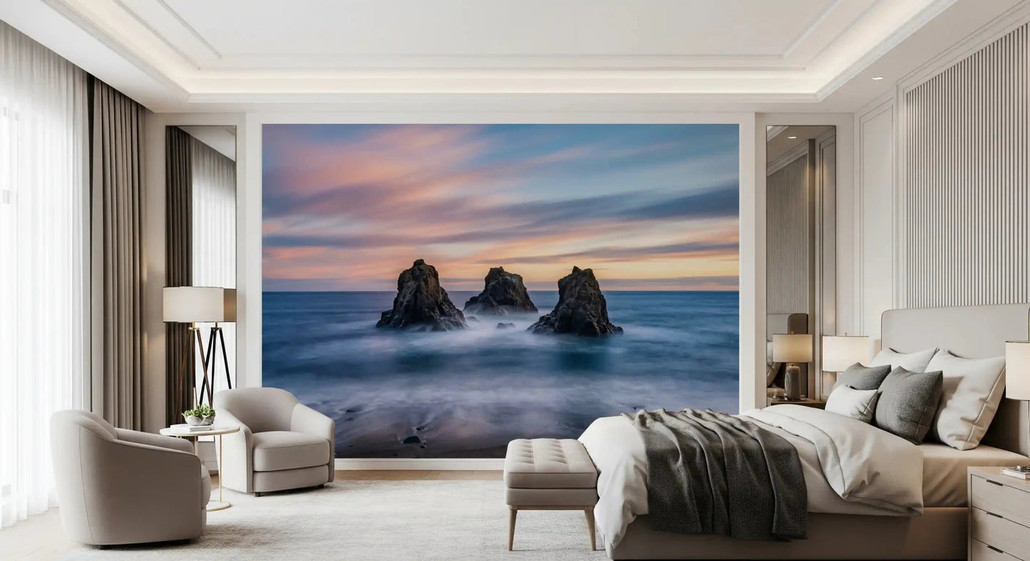 Calm coastal wall mural showing sea stacks, blue surf, and a soft sunset horizon