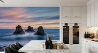 Nature ocean wall mural featuring dark rock formations and pastel horizon light