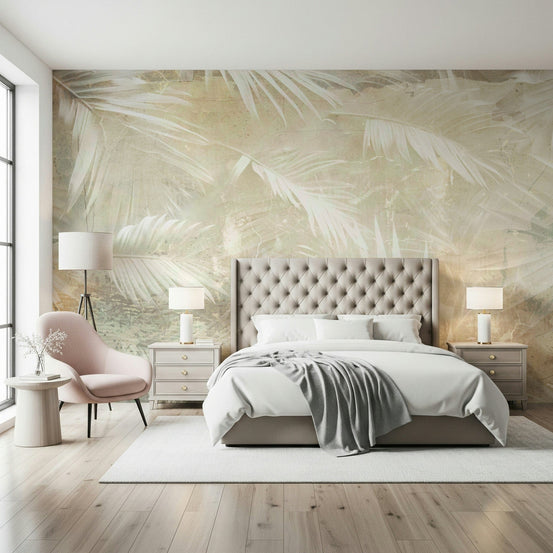 Ethereal Palms wallpaper mural with faded white palm fronds behind a tufted beige bed and pink armchair in a soft bedroom